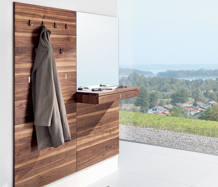 Luxury high-end modern coat rack shown in walnut and with an integrated mirror