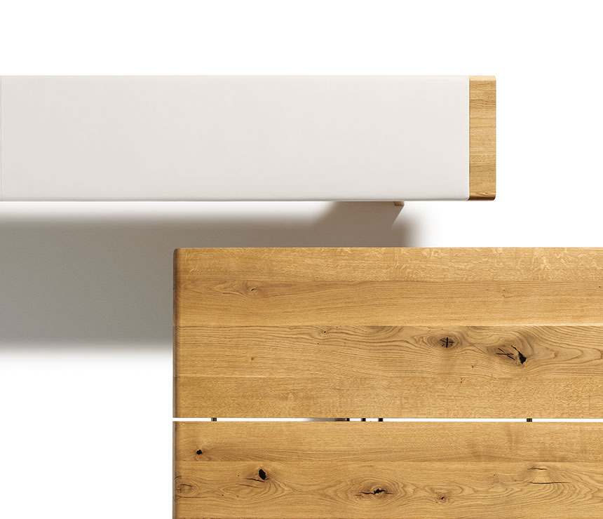 Top detail view of the Nox wood dining table and leather-padded bench - both shown in oak
