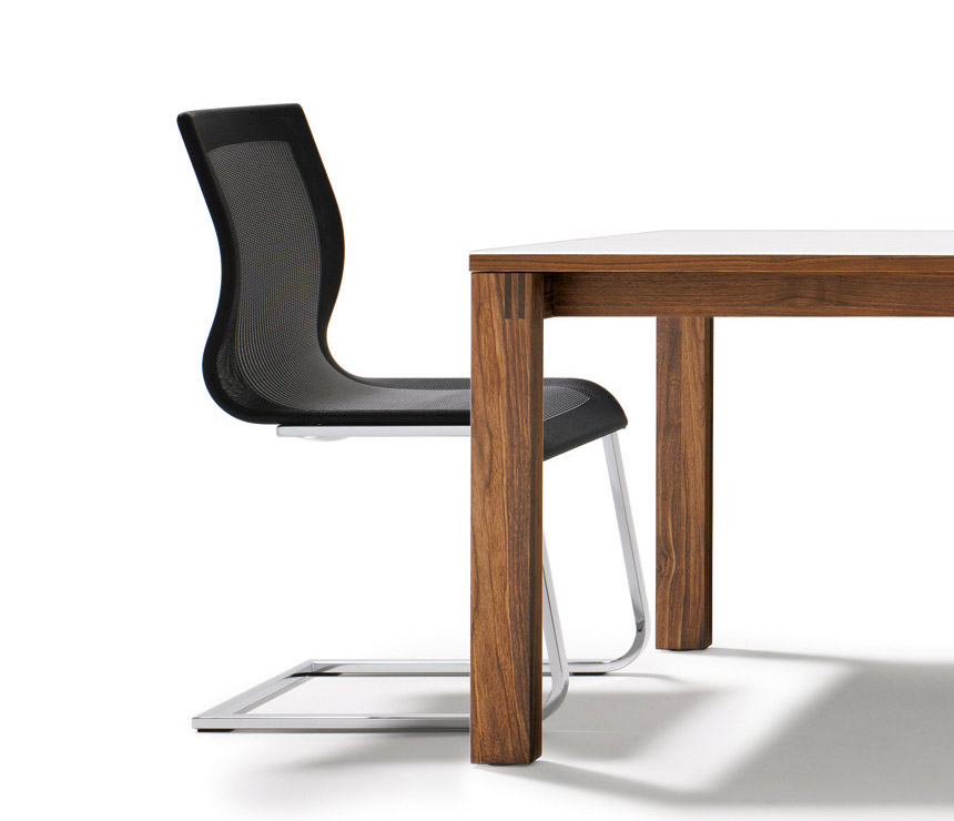 Side view of the Magnum strick-tex cantilever dining chair shown with a Magnum table