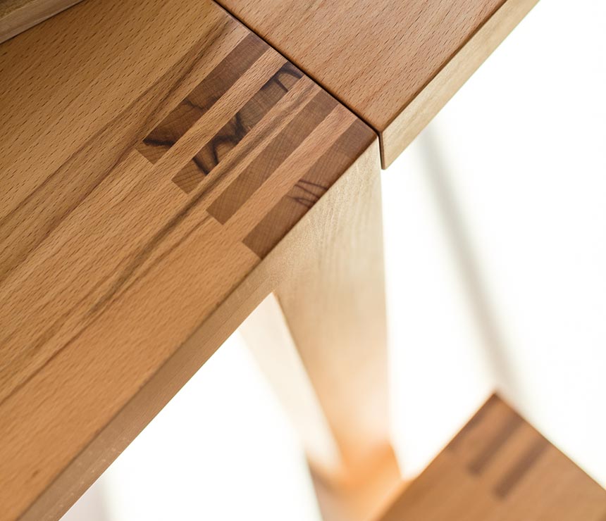 Corner and extension detail close-up of the Loft solid wood dining table - shown in beech heart