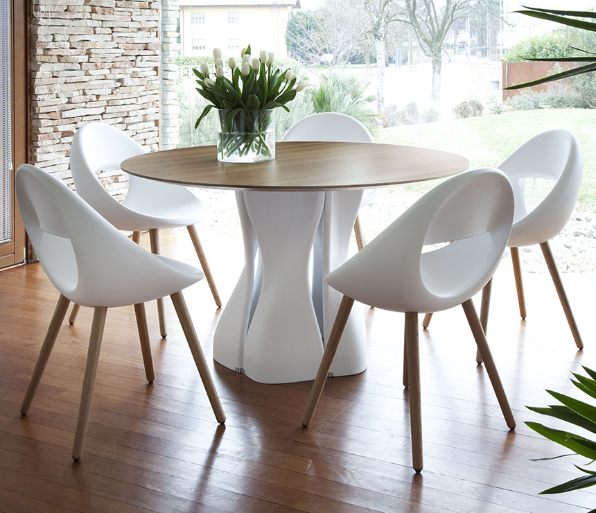 The 217 dining table shown with a round walnut table top and a white pedestal base