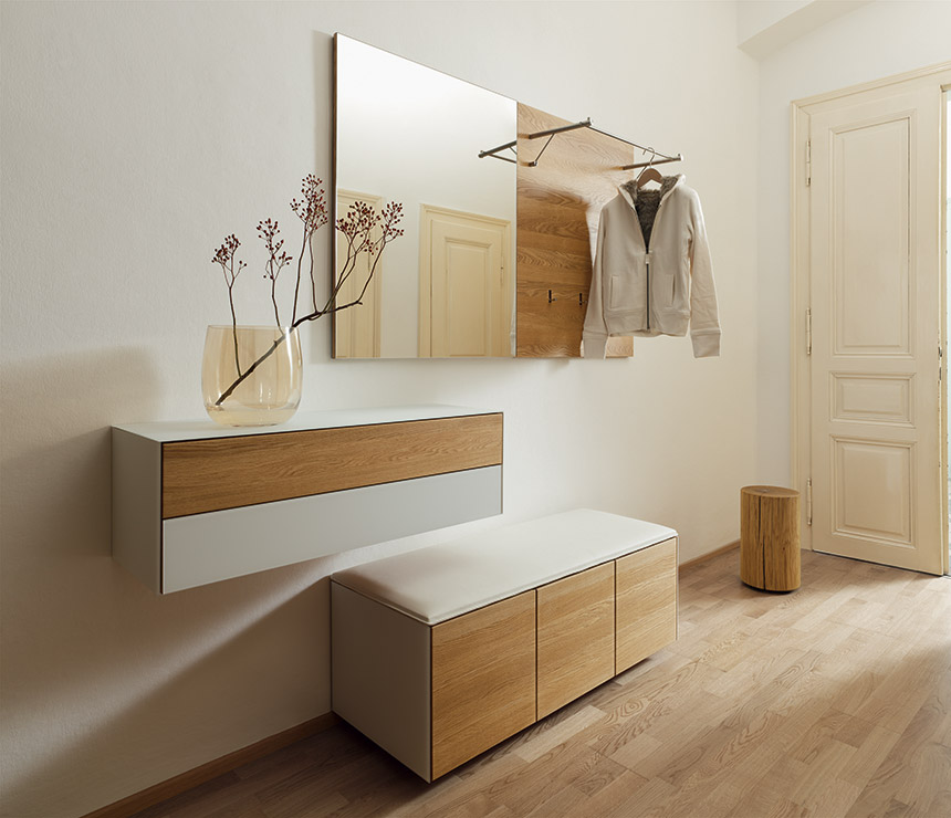 White leather-upholstered hallway bench with wall cabinet and mirror